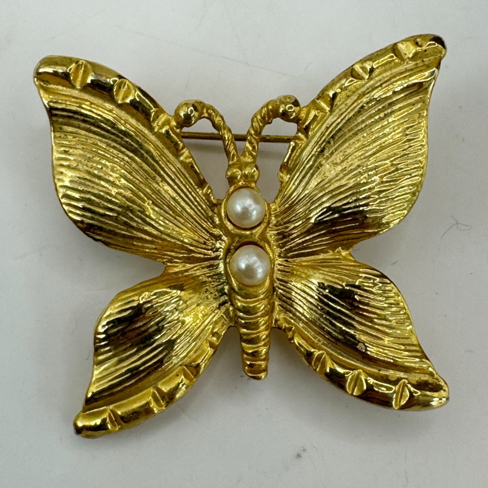 Vintage gold tone textured butterfly brooch with two faux pearls in body